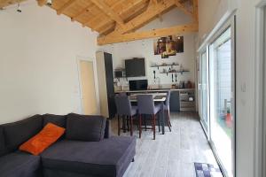ein Wohnzimmer mit einem Sofa und eine Küche mit einem Tisch in der Unterkunft Chai Callie, ancien Chai meublé in Cognac