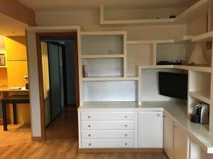 a kitchen with white cabinets and a flat screen tv at Apartamento en Formigal in Formigal