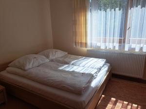 an unmade bed in a bedroom with a window at Willa Małgorzata pod skocznią in Zakopane