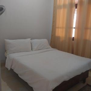 a bed with white sheets and pillows in a room at White villa resort dodangoda in Kalutara