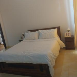 a bedroom with a large bed with white sheets and pillows at White villa resort dodangoda in Kalutara