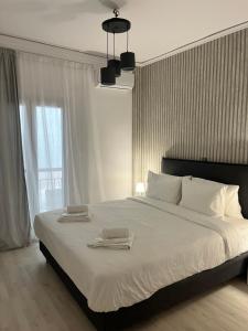 a bedroom with a large bed with two towels on it at Metropolitan Complex Apartment Faliro in Piraeus