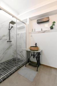 a bathroom with a shower and a table with a sink at Casa Mourisca - Albino d'Óbidos in Óbidos