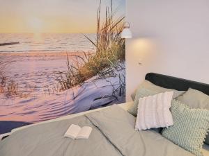 a bedroom with a bed with a painting of the beach at Friesenperle in Tönning
