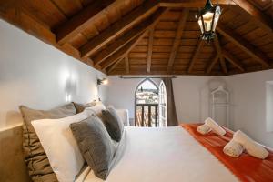 um quarto com uma grande cama branca e uma janela em Casa Mourisca - Albino d'Óbidos em Óbidos