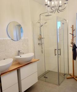 a bathroom with two sinks and a glass shower at Friesenperle in Tönning