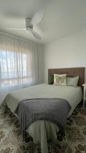 1 dormitorio con 1 cama y ventilador de techo en Charming Beachfront apartment, en Murcia