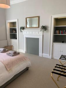 a bedroom with a bed with a fireplace and a mirror at The Old Bank House - Ross-on-Wye in Ross on Wye