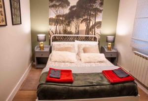 a bedroom with a large bed with red pillows on it at La casa del elefante in Valladolid