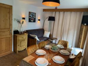 a living room with a table and a couch at Côté DÔMES in Saint-Gervais-les-Bains