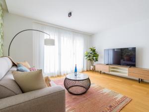 a living room with a couch and a tv at Sea City by CanariasGetaway in Las Palmas de Gran Canaria