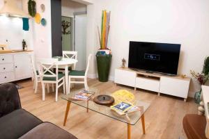 a living room with a couch and a tv and a table at La casa del elefante in Valladolid