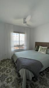 a bedroom with a bed with a ceiling fan at Charming Beachfront apartment in Murcia