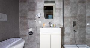 uma casa de banho com um chuveiro, um lavatório e um WC. em Cedrus Hotel em Antália