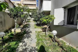 a walkway with trees and a building at Home Garden in Igoumenitsa