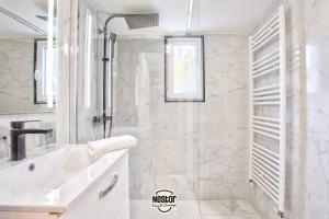 a white bathroom with a sink and a shower at La Casa Valens - Pétanque, convivial & atypique in Caen