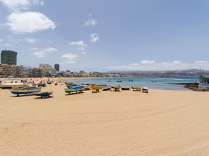 uma praia com cadeiras e barcos na areia em Urban Square 3A5 By CanariasGetaway em Las Palmas de Gran Canaria