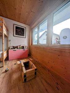 Cette chambre est dotée de murs en bois et d'une grande fenêtre. dans l'établissement Casa LeYu mitten in Ruschein, à Ruschein