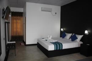 1 dormitorio con 1 cama grande con almohadas azules en Green Lake View Yala Resort, en Tissamaharama