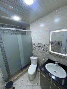 bagno con servizi igienici, lavandino e specchio di Appartement équipé luxe 
