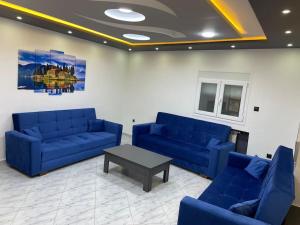 a living room with blue couches and a table at Appartement équipé luxe 