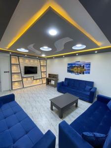 - un salon avec des canapés bleus et une table dans l'établissement Appartement équipé luxe, 