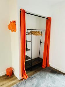 a closet with orange curtains and a ladder at ORANGE APPART in Tourcoing