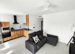 sala de estar con sofá y cocina en Maison neuve moderne en Los Baños