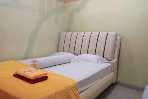 Un pat sau paturi într-o cameră la OYO 93532 Kost Nian Syariah