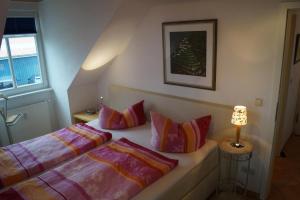 1 dormitorio con 2 camas con almohadas y lámpara en Wunderschöne Fewo direkt am Haff mit 2 Slz, en Rerik