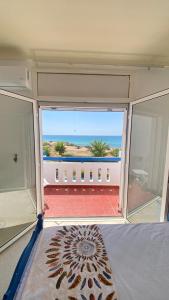 a bedroom with a view of the ocean from a balcony at Dar el Zyne in Nabeul