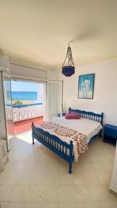 a bedroom with a bed with a view of the ocean at Dar el Zyne in Nabeul