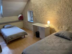 a bedroom with two beds and a desk and a window at Gite de la Haure, Lourdes in Lézignan