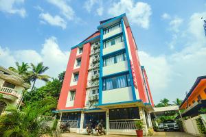 un edificio colorido con gente delante de él en Relax Holiday Home,Margao Railway Station, en Margao