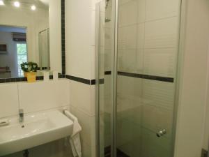 y baño con ducha acristalada y lavamanos. en Komfortable Fewo - modern, strandnah, Balkon, mit Wellnessbereich, en Baabe