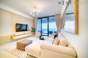a living room with a couch and a tv at Address JBR Sea View, Jumeirah Beach Residence, Dubai Marina - Mint Stay in Dubai