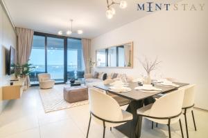 a dining room and living room with a table and chairs at Address JBR Sea View, Jumeirah Beach Residence, Dubai Marina - Mint Stay in Dubai