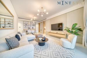 a living room with white furniture and a tv at Address JBR Sea View, Jumeirah Beach Residence, Dubai Marina - Mint Stay in Dubai
