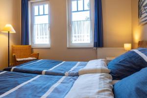 奥斯赛拜-屈隆斯博恩Schönes Apartment mit Balkon, Parkplatz, WLAN的有两张床和两扇窗户的卧室