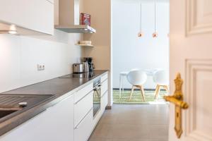 a kitchen with white cabinets and a counter top at Großzügige Designer- Luxuswohnung für 2 Personen in stilvoller Altbauvilla in Heringsdorf +18 photos