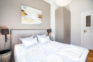 a white bed with white pillows in a bedroom at Großzügige Designer- Luxuswohnung für 2 Personen in stilvoller Altbauvilla in Heringsdorf
