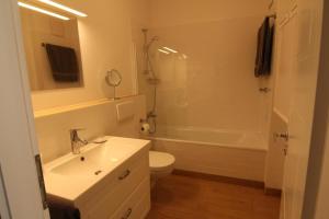 比恩多夫的住宿－Ostsseresidenz Wohnung 17，浴室配有盥洗盆、卫生间和浴缸。