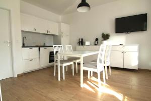 比恩多夫的住宿－Ostsseresidenz Wohnung 17，白色的厨房配有白色的桌子和椅子