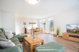 TV a/nebo společenská místnost v ubytování Ferienhaus "Louisa" mit Lademöglichkeit, Garten und Badewanne