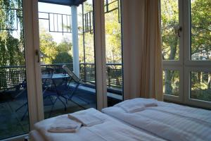 a bedroom with a bed and a balcony with windows at Charmante Fewo mit direktem Strandzugang, Badewanne, Saunabereich im Haus in Heringsdorf
