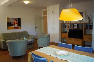 a living room with a table and a yellow light at Charmante Fewo mit direktem Strandzugang, Badewanne, Saunabereich im Haus in Heringsdorf