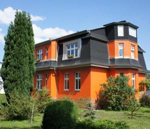 uma casa laranja e preta com um telhado preto em Großzügige Fewo mit Terrasse, Strandkorb em Bansin