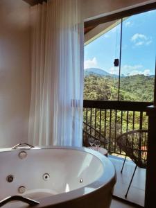 a bath tub in a bathroom with a view at Encontro dos Vales in Visconde De Maua