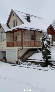 une maison avec de la neige à l'avant dans l'établissement Big garden wood house, à Kolgecaj
