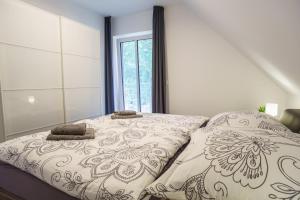 uma cama com um edredão branco e uma janela em charmantes Ferienhaus für 4 Personen mit Sauna und 2 Bädern em Korswandt